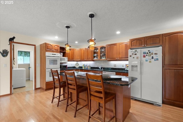 110 Dolph Dr, Ariel, WA 98603 - kitchen with white appliances, light wood finished floors, a kitchen bar, a center island, and pendant lighting