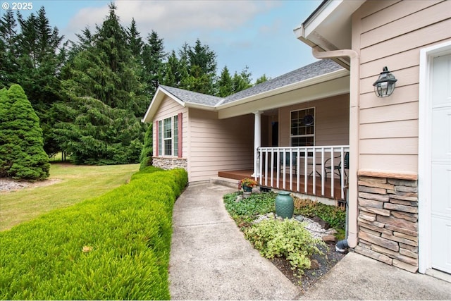 110 Dolph Dr, Ariel, WA 98603 - view of exterior entry featuring a porch, stone siding, a yard, and a shingled roof