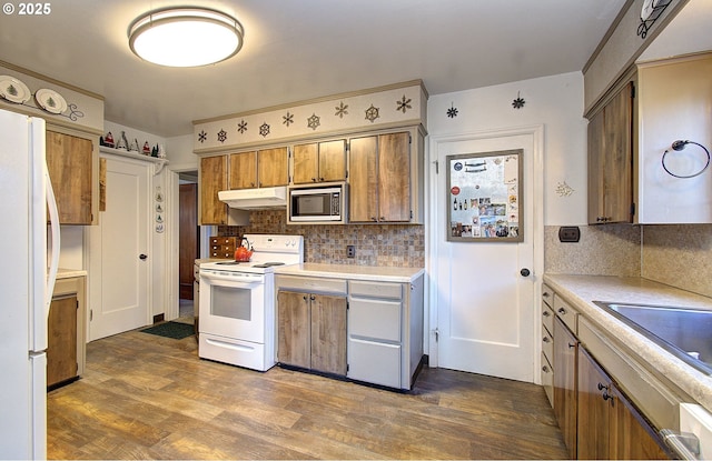 kitchen with sink, white appliances, backsplash, and dark wood-type flooring