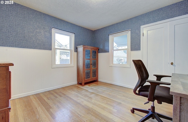 office space featuring a textured ceiling and light wood-type flooring