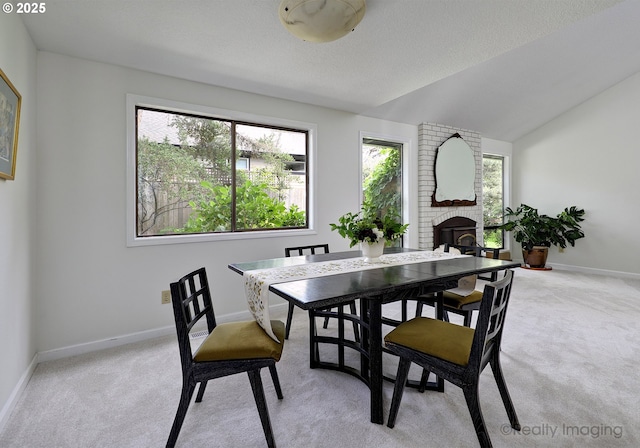 12420 Orchard Hill Rd, Lake Oswego, OR 97035 - dining area featuring baseboards, a fireplace, vaulted ceiling, and light colored carpet