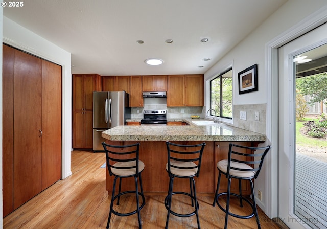 12420 Orchard Hill Rd, Lake Oswego, OR 97035 - kitchen featuring appliances with stainless steel finishes, a sink, light countertops, a peninsula, and under cabinet range hood