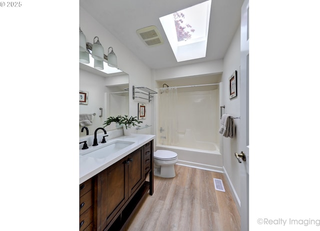 12420 Orchard Hill Rd, Lake Oswego, OR 97035 - full bathroom with vanity, wood finished floors, toilet,  shower combination, and a skylight