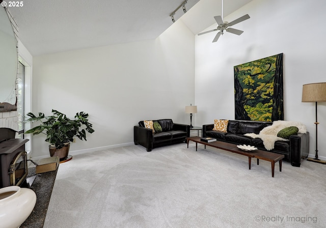 12420 Orchard Hill Rd, Lake Oswego, OR 97035 - living room with carpet floors, ceiling fan, a wood stove, and high vaulted ceiling