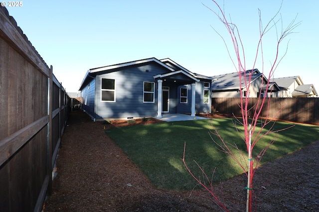 back of property with a patio area and a lawn