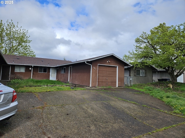 ranch-style house featuring a garage and aphalt driveway