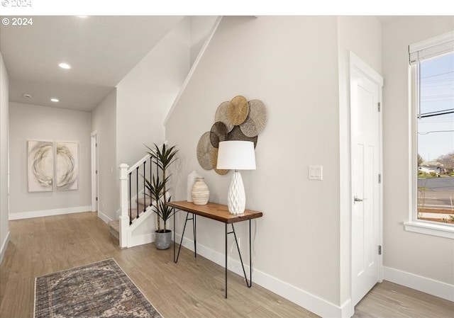 hall featuring recessed lighting, baseboards, wood finished floors, and stairs