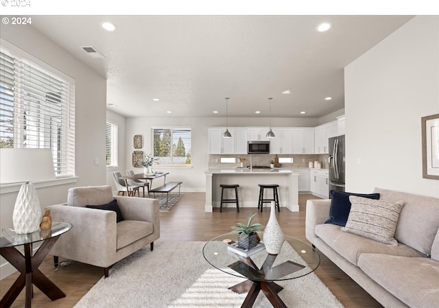 living area featuring visible vents, recessed lighting, and wood finished floors