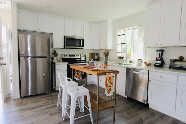 611 SE 142nd Ave Unit B, Portland, OR 97233 - kitchen featuring stainless steel appliances, dark wood-type flooring, white cabinetry, and light countertops