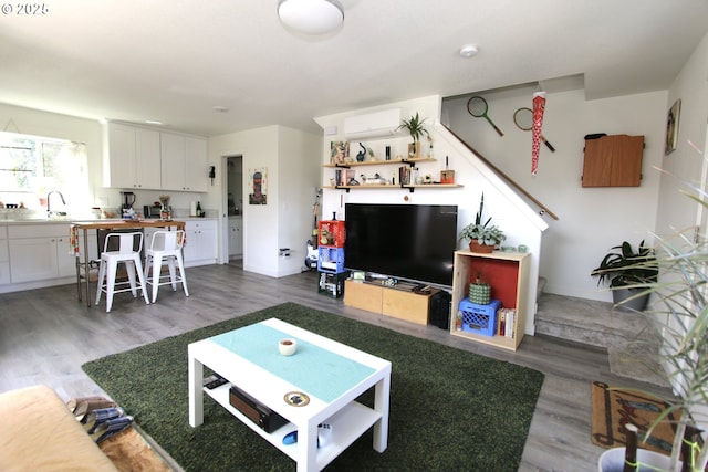 611 SE 142nd Ave Unit B, Portland, OR 97233 - living area featuring wood finished floors, a wall mounted AC, and baseboards