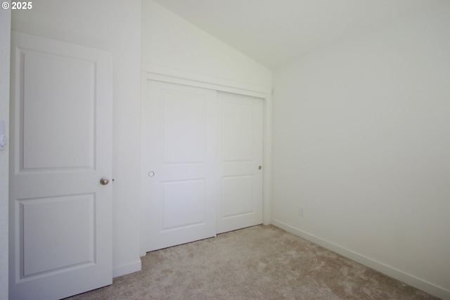 611 SE 142nd Ave Unit B, Portland, OR 97233 - unfurnished bedroom with light colored carpet, lofted ceiling, a closet, and baseboards