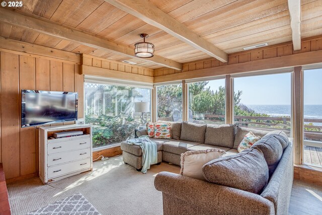 living area featuring wooden walls, carpet floors, beamed ceiling, visible vents, and wood ceiling