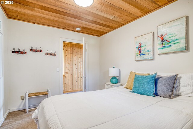 carpeted bedroom featuring baseboards and wood ceiling