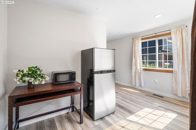 108 SE 133rd Ave, Portland, OR 97233 - kitchen featuring visible vents, black microwave, wood finished floors, baseboards, and freestanding refrigerator