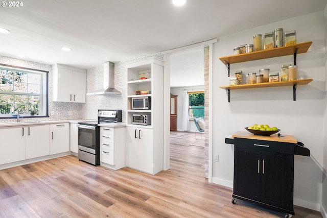 108 SE 133rd Ave, Portland, OR 97233 - kitchen featuring open shelves, wall chimney range hood, light countertops, a sink, and stainless steel appliances