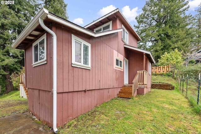 view of property exterior featuring fence and a lawn