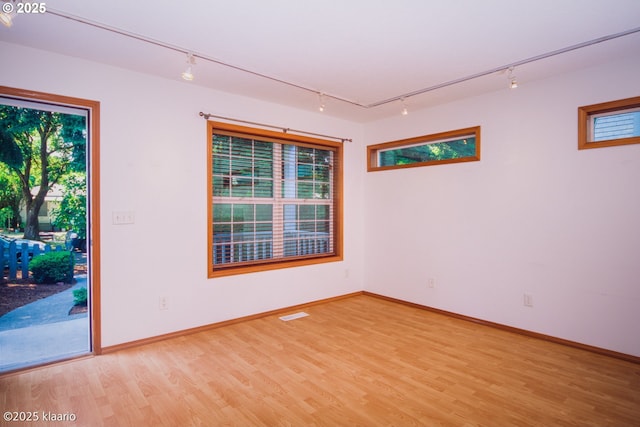 7942 N Hurst Ave, Portland, OR 97203 - spare room with rail lighting, light wood-style floors, and healthy amount of natural light