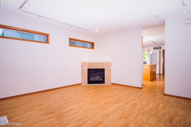 7942 N Hurst Ave, Portland, OR 97203 - unfurnished living room featuring track lighting, light wood finished floors, baseboards, and a fireplace