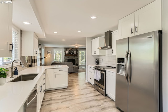 1736 Regency St, West Linn, OR 97068 - kitchen with stainless steel appliances, wall chimney exhaust hood, recessed lighting, a stone fireplace, and backsplash