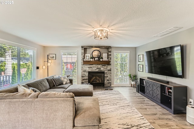 1736 Regency St, West Linn, OR 97068 - living area with light wood-type flooring, a textured ceiling, and a fireplace