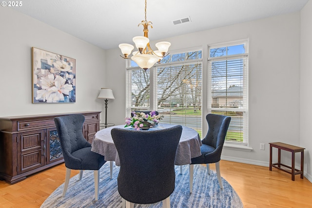 dining area with a chandelier and light hardwood / wood-style flooring