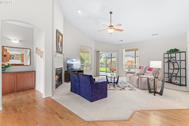 living room featuring ceiling fan, light hardwood / wood-style floors, and lofted ceiling