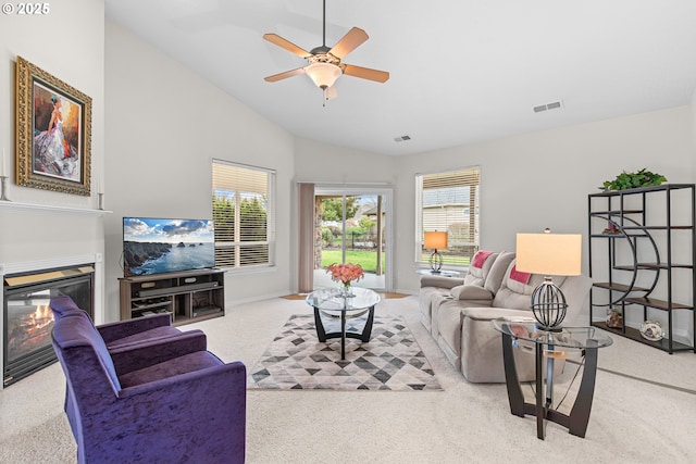 carpeted living room with ceiling fan, a healthy amount of sunlight, and vaulted ceiling