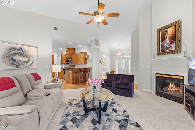 living room with light colored carpet, vaulted ceiling, and ceiling fan