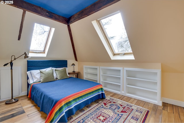 2122 NW Everett St, Portland, OR 97210 - bedroom with a skylight, multiple windows, wood-type flooring, baseboards, and lofted ceiling