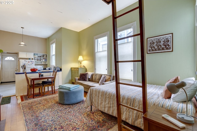 2122 NW Everett St, Portland, OR 97210 - bedroom featuring freestanding refrigerator, multiple windows, and light wood-style flooring