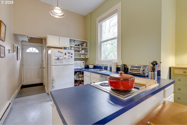 2122 NW Everett St, Portland, OR 97210 - kitchen featuring white appliances, a baseboard radiator, dark countertops, and white cabinetry