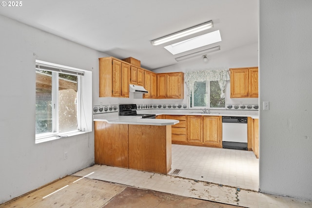 58897 Constance Dr, Bandon, OR 97411 - kitchen featuring white dishwasher, electric range, a skylight, under cabinet range hood, and healthy amount of natural light