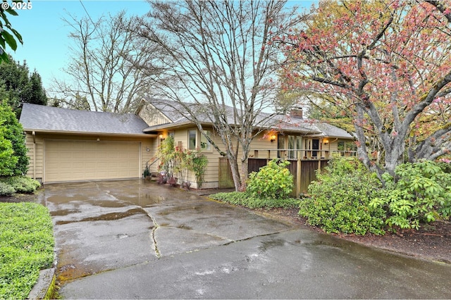 ranch-style home with concrete driveway, fence, and a garage