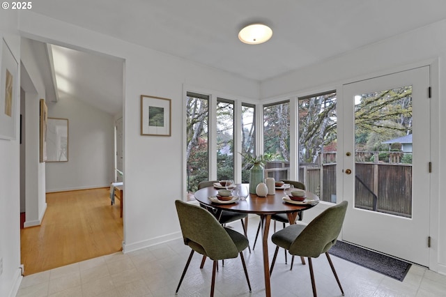 dining space featuring baseboards and light floors
