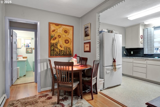 dining area featuring light wood-type flooring and a baseboard radiator
