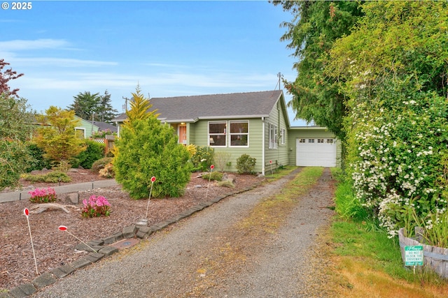 view of front of house featuring a garage, a shingled roof, and driveway
