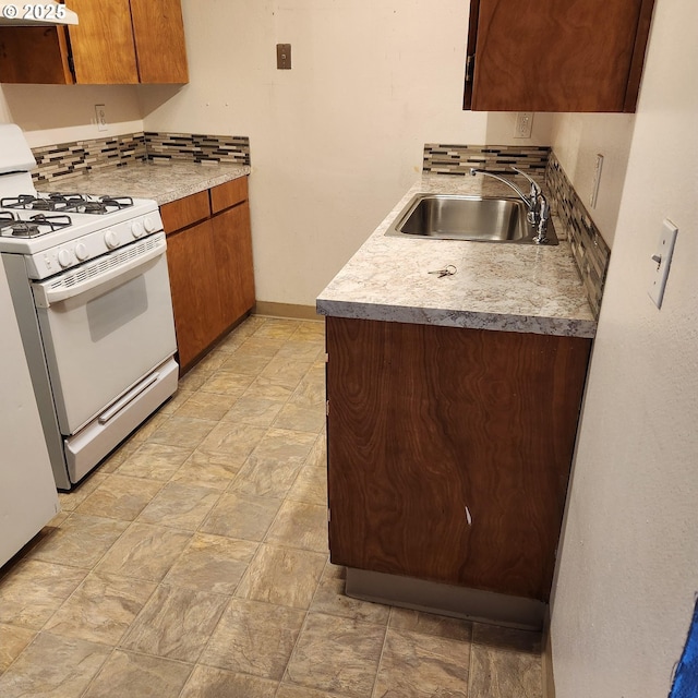 kitchen with exhaust hood, white range with gas cooktop, sink, and backsplash