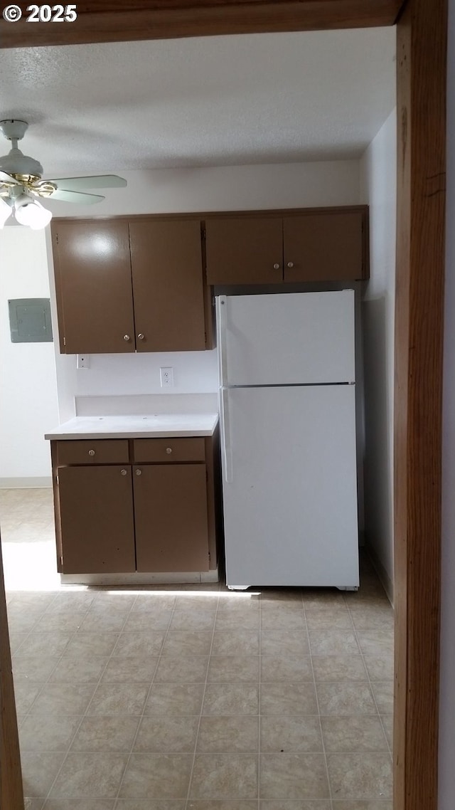 kitchen with white refrigerator, ceiling fan, and dark brown cabinetry