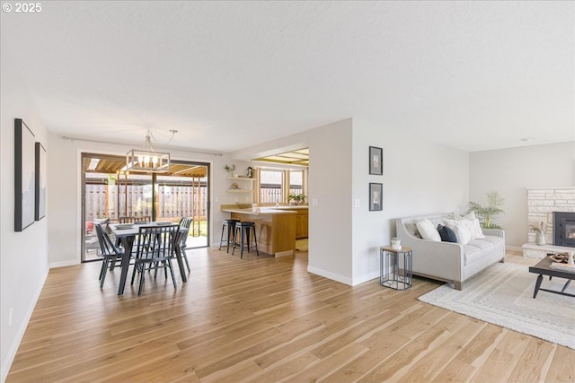 1725 SE Cochran Dr, Gresham, OR 97080 - dining room with light wood-type flooring, a chandelier, and a glass covered fireplace