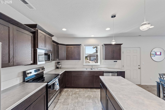 764 Seacrest Dr, Bandon, OR 97411 - kitchen with appliances with stainless steel finishes, a sink, dark brown cabinets, light countertops, and pendant lighting