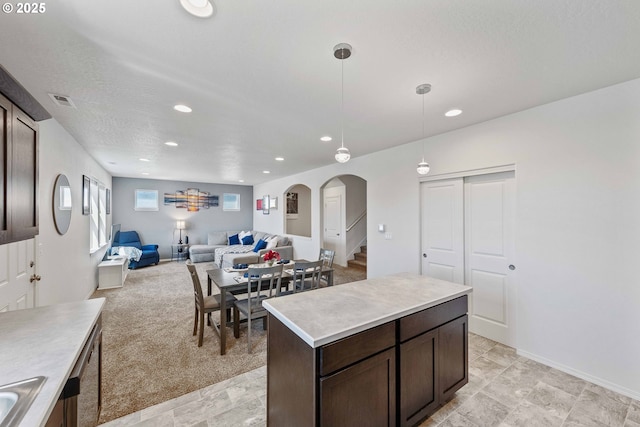 764 Seacrest Dr, Bandon, OR 97411 - kitchen featuring dark brown cabinets, recessed lighting, open floor plan, light countertops, and arched walkways