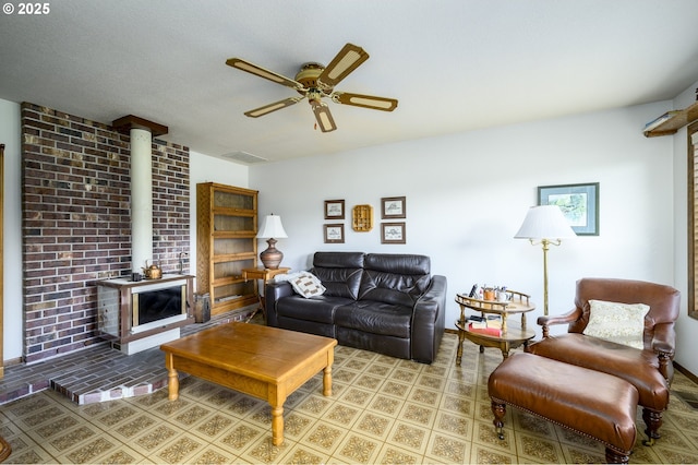 living room with a wood stove, a textured ceiling, and ceiling fan