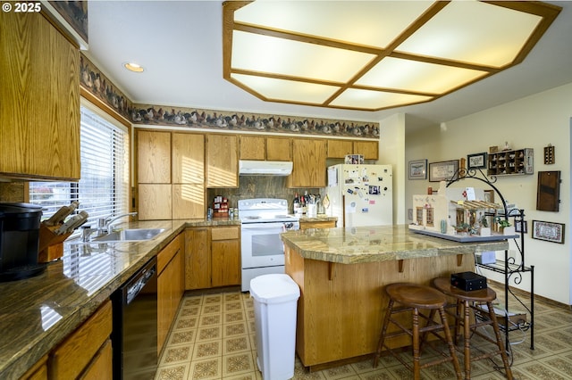 kitchen with a kitchen breakfast bar, sink, and white appliances