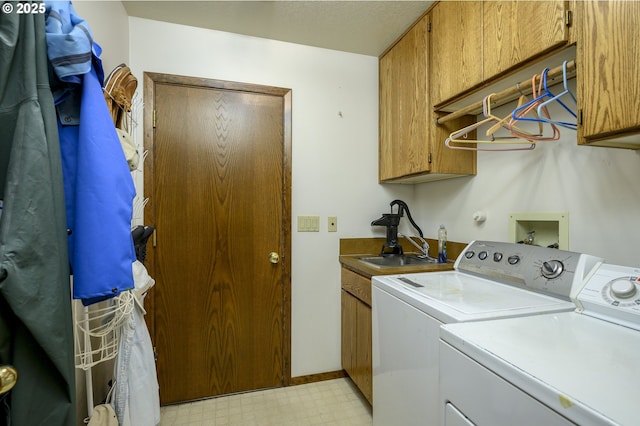 clothes washing area with cabinets, sink, and independent washer and dryer