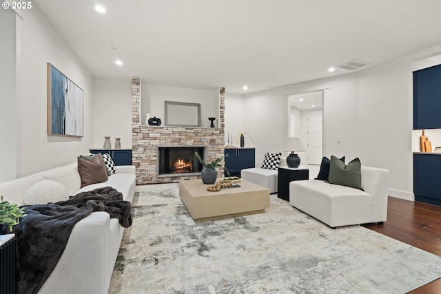 living area with wood finished floors, recessed lighting, and a fireplace