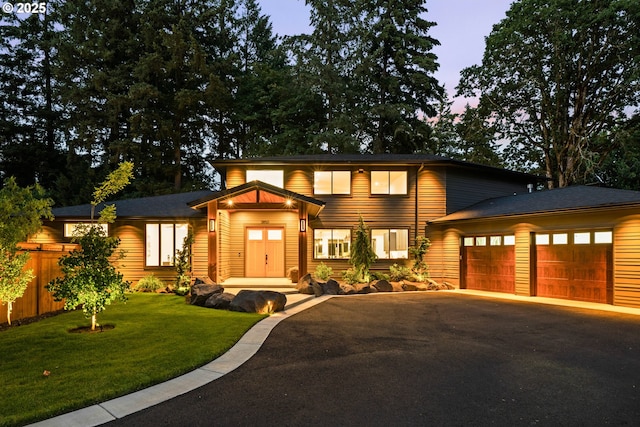 view of front of home with asphalt driveway and an attached garage