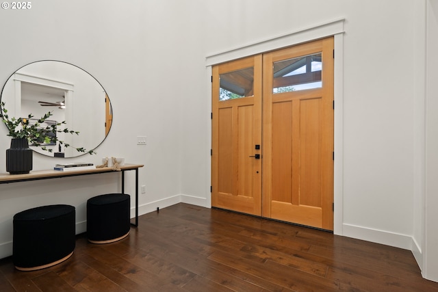 foyer entrance with dark wood finished floors, baseboards, and ceiling fan