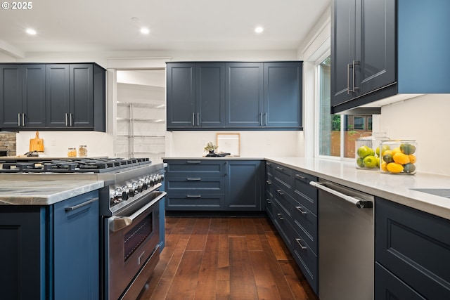 kitchen featuring appliances with stainless steel finishes, dark wood-style floors, decorative backsplash, light countertops, and recessed lighting