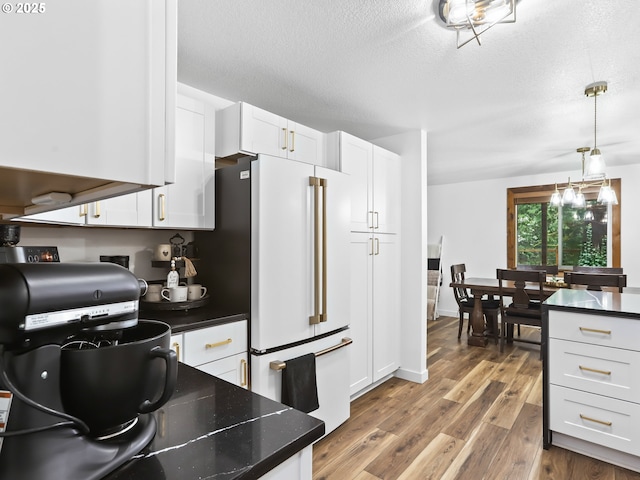 54934 E Kirkwood Dr, Sandy, OR 97055 - kitchen featuring white fridge, wood finished floors, white cabinetry, pendant lighting, and a textured ceiling