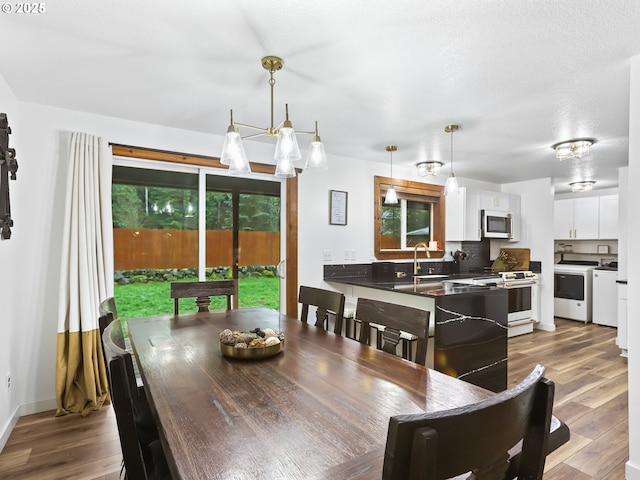 54934 E Kirkwood Dr, Sandy, OR 97055 - dining room with wood finished floors, washer and clothes dryer, and a chandelier
